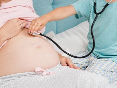 Schwangere Frau wird von einem Kind untersucht