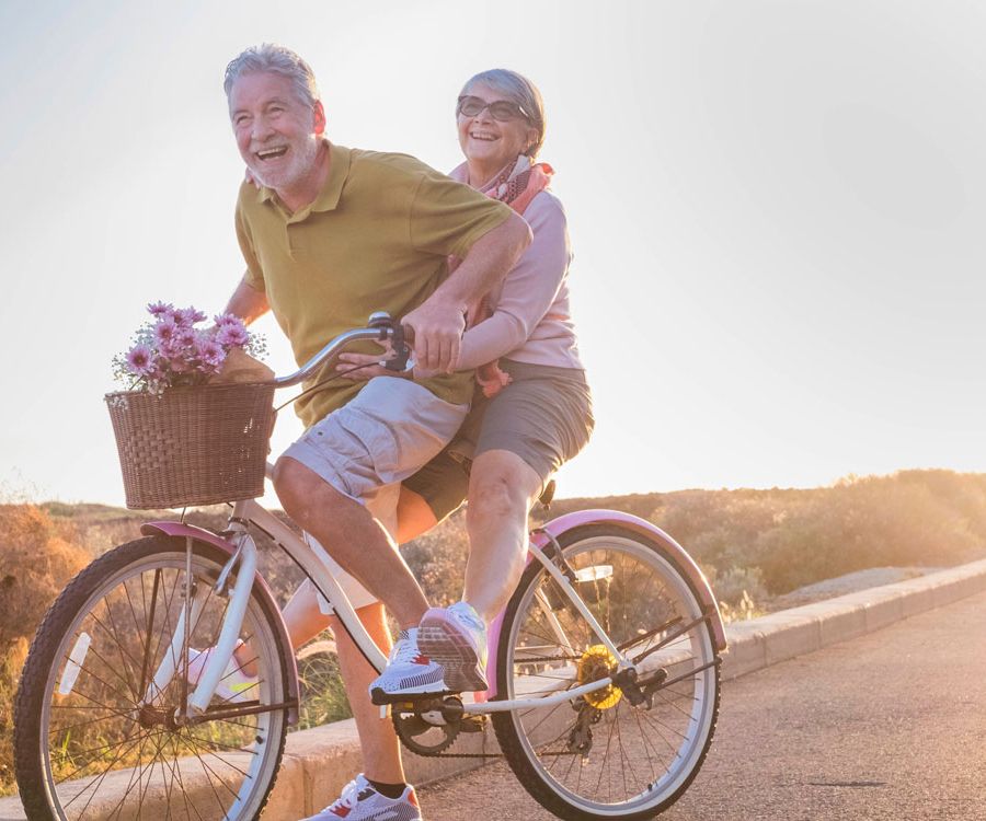 Älteres Pärchen lachend gemeinsam auf einem Fahrrad