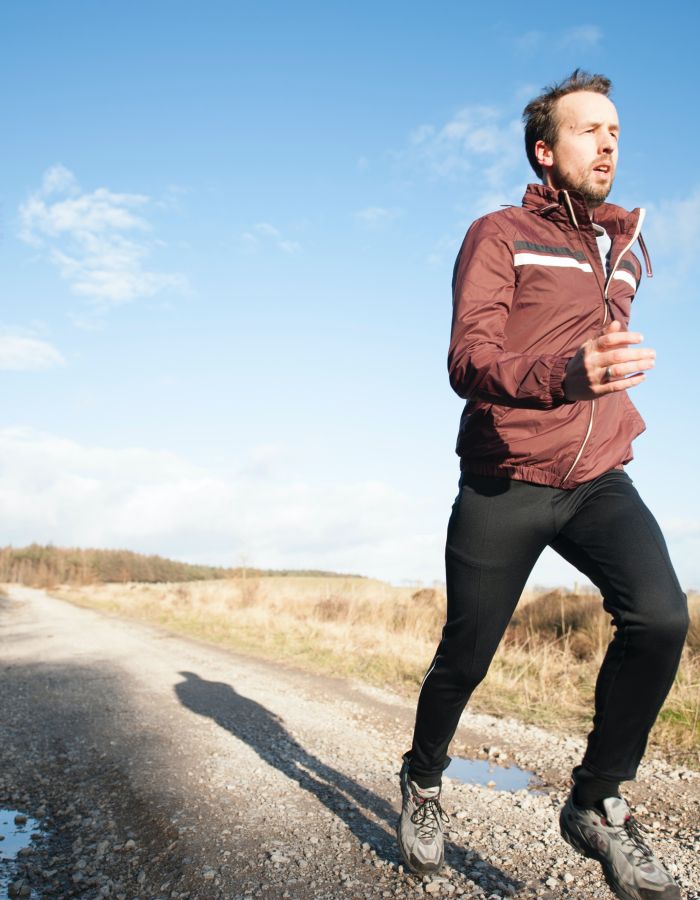 Mann beim Joggen auf einem Feldweg