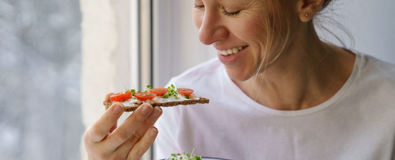 Frau isst ein lecker belegtes Knäckebrot