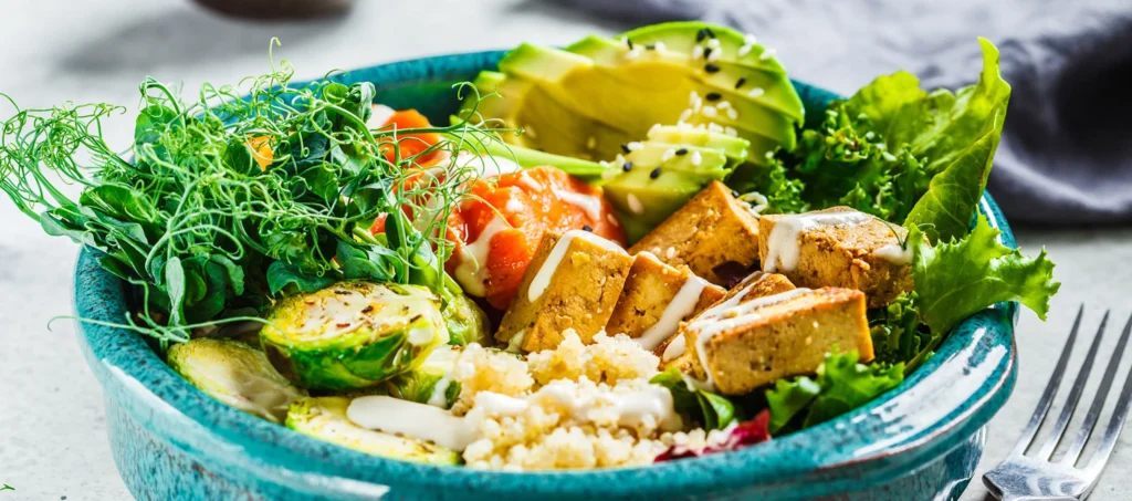Vegane Bowl mit Tofu, Quinoa und Avocado als pflanzliche Eisenquellen