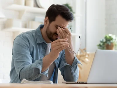 Erschöpfter Mann am Laptop – Müdigkeit als typisches Symptom von Eisenmangel